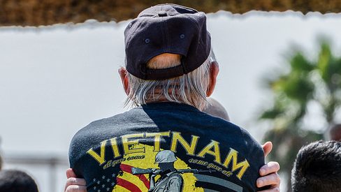 Vietnam Veteran stands with his back to the came; jacket reads, "Vietnam" across the back