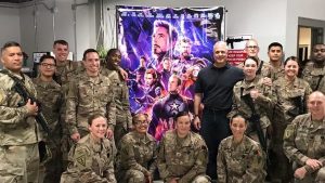 Troops in Afghanistan pose in front of an Avengers poster before a free screening of the blockbuster movie.