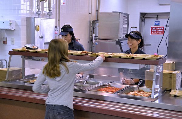 Exchange associates serves lunch to military school kids overseas