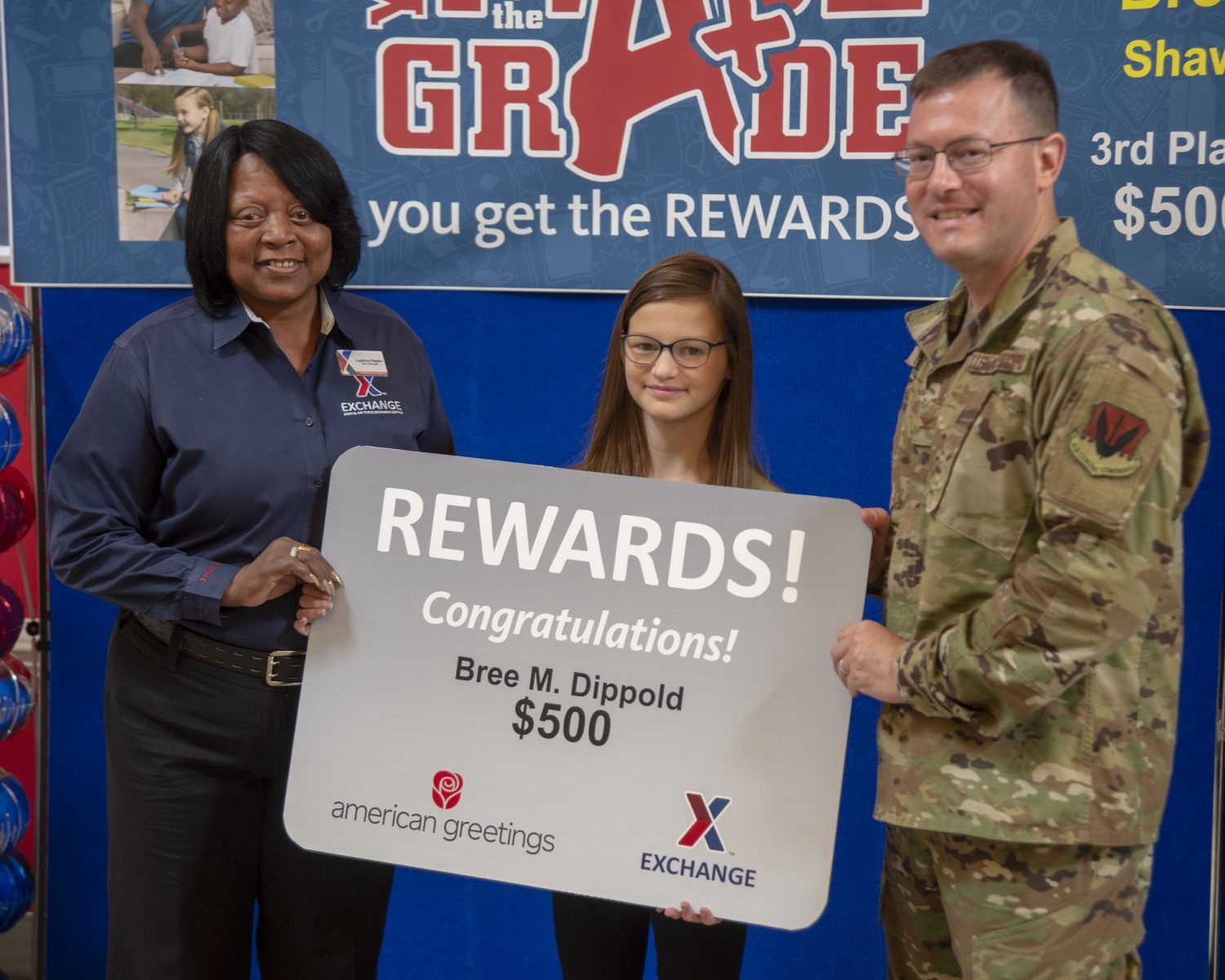 Leatrice Peyton, Shaw Exchange store manager, and Col. Richard Brown, 20th MSG Commander, present Bree Dippold with her $500 gift card