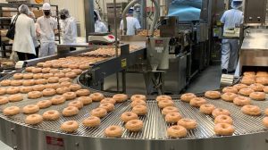 Photo of Krispy Kreme doughnuts rolling off bakery line at the Exchange's new Korea distribution center and bakery