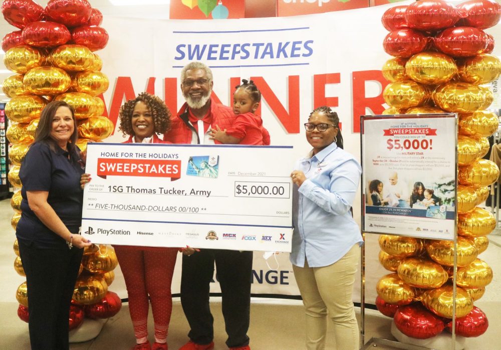 Photo of Redstone Arsenal Exchange officials presenting retired Army 1st Sgt. Thomas Tucker with an oversized $5,000 check, the grand prize in the MILITARY STAR Home for the Holidays sweepstakes, Dec. 20 at the Redstone Exchange.