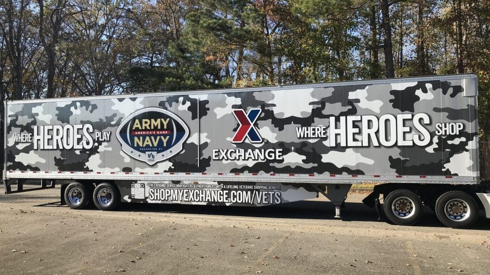 The Exchange's latest patriotic trailer wrap, reading "Where Heroes Play, Where Heroes Shop" against a camoflauge background.