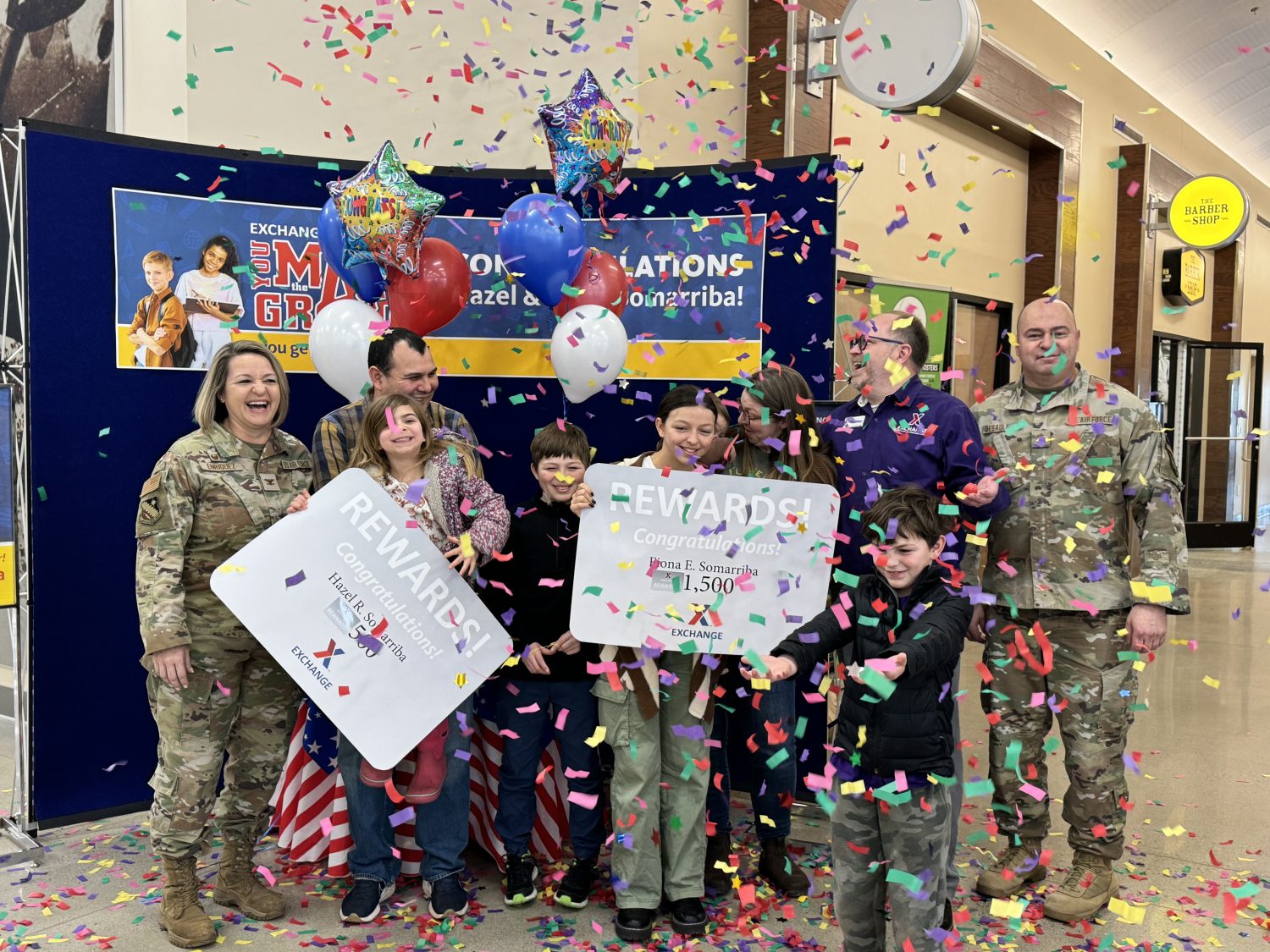 Col. Taona Enriquez, left, commander, 66th Air Base Group, and Chief Master Sgt. Charles Desaulniers, right, acting command chief, 66th Air Base Group, joined Hanscom Exchange General Manager Dale Killip in presenting the prizes to Fiona and Hazel Somarriba during a presentation at the BX on Feb. 10.