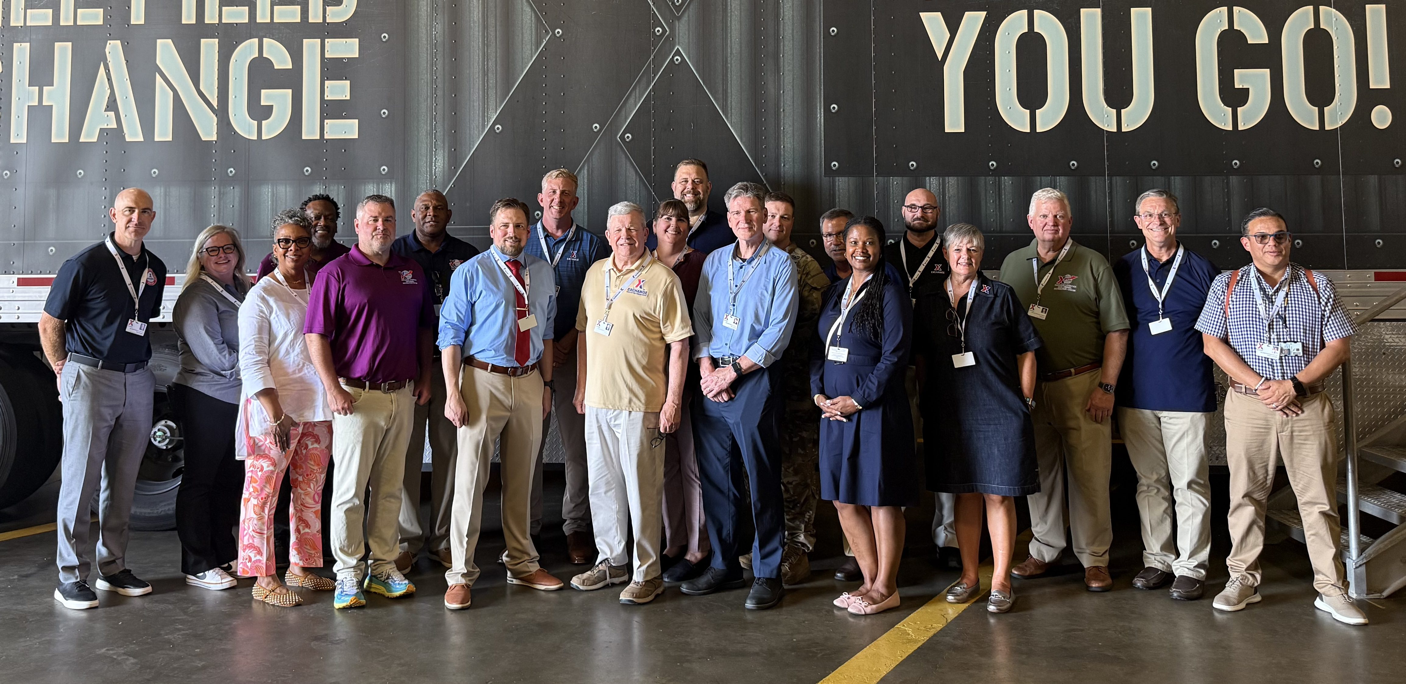 DASD for MC&FP Stephen B. Simmons, center in tie, with Exchange Director/CEO Tom Shull (center, yellow shirt) and others during Simmons' Aug. 4 visit to the Dan Daniel Distribution Center. Pictured, from left: Exchange Deputy Director/CFO/EVP Brad Bingham; Logistics Vice President Morgan Meeks; Chief Operating Officer/EVP Marla Randolph; Assistant DDDC Manager Ron Willis; DDDC Manager David Hill; Supply Chain Transportation Vice President Fred Hannah; Mr. Simmons; EVP/CIO Chad Lucas; Mr. Shull; Associate Director, Business Policy, Morale, Welfare and Recreation and Resale Policy Pyper Brenner; Program Analyst, Business Policy, MC&FP Scott Peabody; Director, Morale, Welfare and Recreation and Resale Policy Glenn Garrison; MAJ Todd Castles, Mr. Shull's Executive Officer; Logistics EVP Alan French; Military OneSource Outreach Program Manager Erin King; Corporate Policy Vice President Brad Nisbett; SVP, Brand Marketing Sandi Lute; Senior Vice President of Government Affairs Gregg Cox; EVP/Corporate Communication Officer Judd Anstey; and DASD MC&FP Executive Assistant Matthew Alvarado.