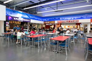 patrons at red table in food court