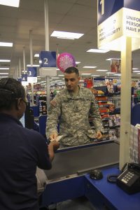 Sharon Edwards accepts cash from Staff Sgt. Emre Eroglu, John F. Kennedy Special Warfare Center and School, for his purchase at the Post Exchange during the holiday season Nov. 7. The Post Exchange offers both convenience and tax-free purchases to Department of Defense ID card holders. (U.S. Army photo by Spc. Taryn Hagerman)